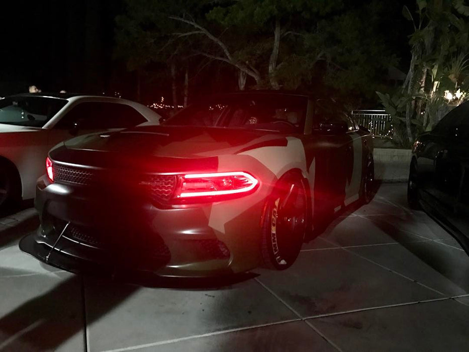 Three quarters view of a Dodge Charger with red headlight DRLs.