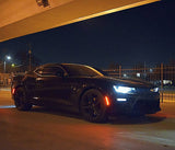 Three quarters view of a Chevrolet Camaro with white headlight and fog light DRLs.