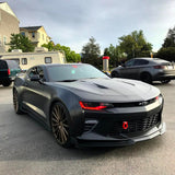 Three quarters view of a black Chevrolet Camaro with red headlight DRLs.