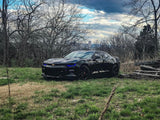 Three quarters view of a black Chevrolet Camaro with blue headlight DRLs.