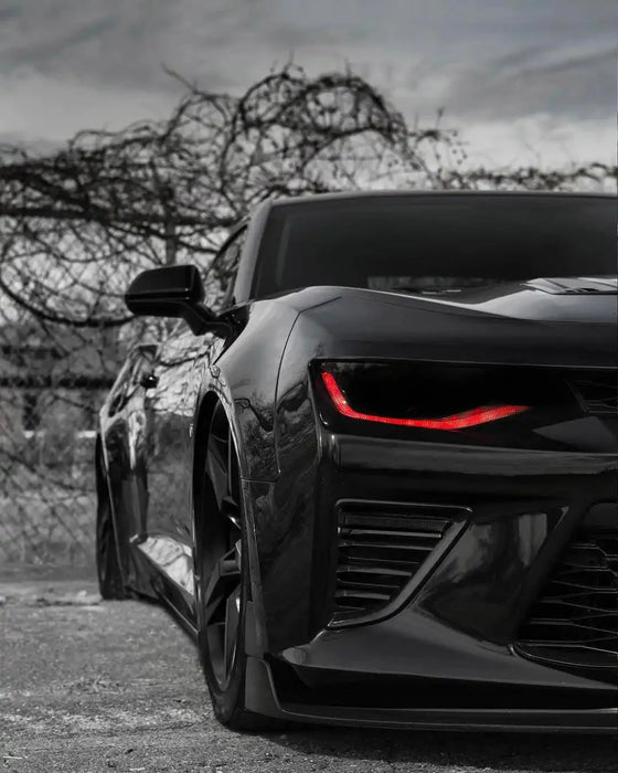 Close-up a Chevrolet Camaro headlight with red DRLs.