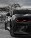 Close-up a Chevrolet Camaro headlight with red DRLs.