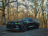 Three quarters view of a black Chevrolet Camaro with green headlight DRLs.