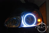 Close-up of white LED headlight halo rings installed on a Smart Car