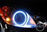 Close-up of white LED headlight halo rings installed on a Smart Car.