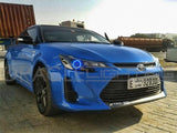 Three quarters view of a Scion tC with blue LED headlight halo rings installed.