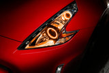 Nissan 370Z headlights with amber LED halo rings installed.