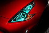 Nissan 370Z headlights with cyan LED halo rings installed.