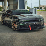 Three quarters view of a black Chevrolet Camaro with green headlight and fog light DRLs.