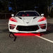 Front view of a white C8 Corvette with red headlight DRLs.