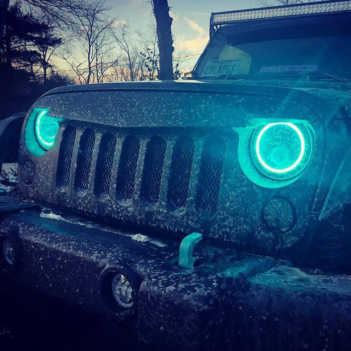 Front end of a Jeep Wrangler with 7" High Powered LED Headlights installed, and cyan halos on.