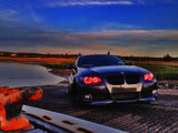 Front end of a BMW 3 Series with red LED headlight halo rings installed.