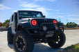 Three quarters view of a Jeep Wrangler JK with red LED headlight halos installed.