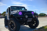 Three quarters view of a Jeep Wrangler JK with purple LED headlight halos installed.