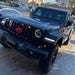 Front end of a Jeep Wrangler JL with amber Pre-Runner Style LED Grill Light Kit installed.