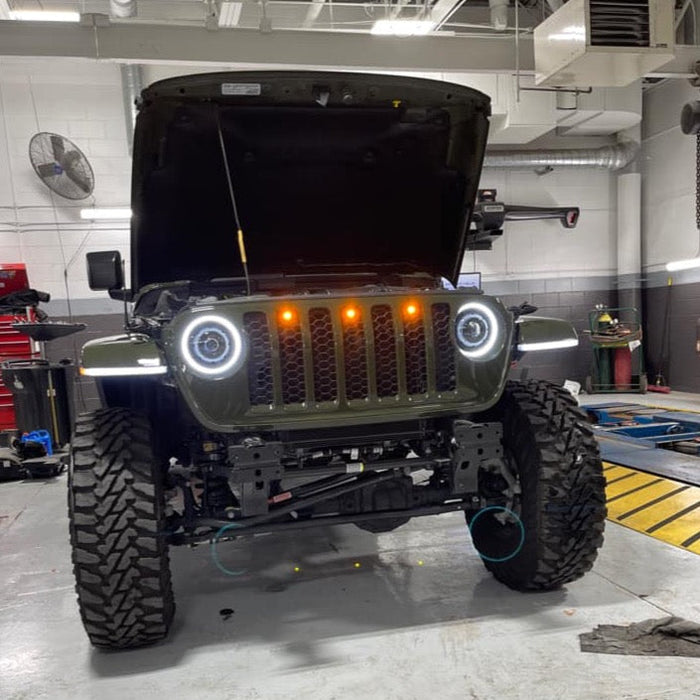 Front end of a Jeep Wrangler JL with amber Pre-Runner Style LED Grill Light Kit installed.