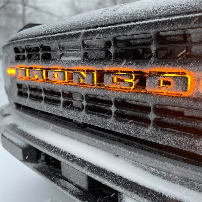 Close-up of amber LED letter badges glowing in the snow