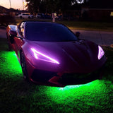 Three quarters view of a C8 Corvette with purple headlight DRLs.