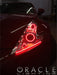 Close-up on a Nissan 370Z headlight with red LED halo rings installed.