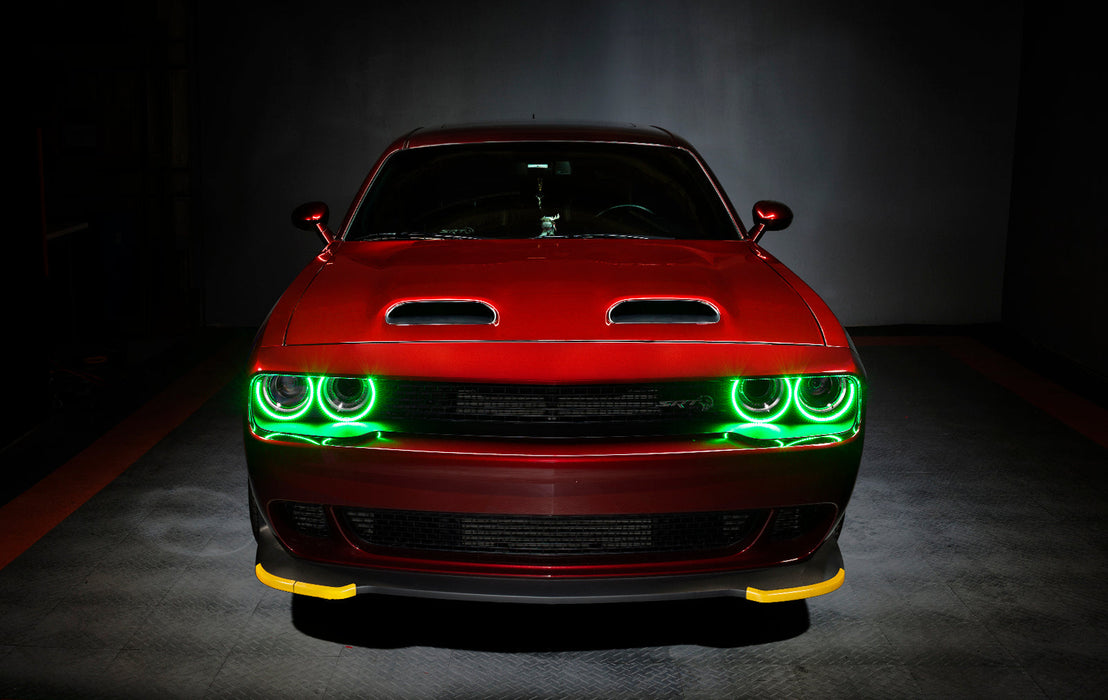 Front view of a red Dodge Challenger with green LED headlight halo rings installed.