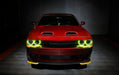 Front view of a red Dodge Challenger with yellow LED headlight halo rings installed.
