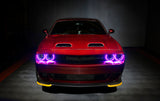 Front end of a red Dodge Challenger with pink halo headlights.