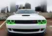 Front end of a white Dodge Challenger with green LED headlight halo rings installed.