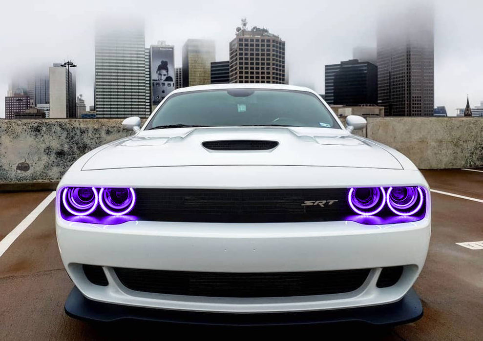 Front end of a white Dodge Challenger with purple LED headlight halo rings installed.