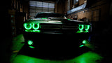 Front end of a Dodge Challenger with green LED headlight halo rings installed.