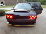 Front end of a black Dodge Challenger with red LED headlight halo rings installed.