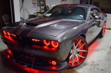 Three quarters view of a silver Dodge Challenger with red LED headlight and fog light halo rings installed.