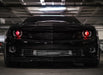 Front end of a black Chevrolet Camaro with red demon eye projectors.