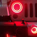 Close-up on the front end of a Jeep with High Performance 20W LED Fog Lights installed, and red halos on.