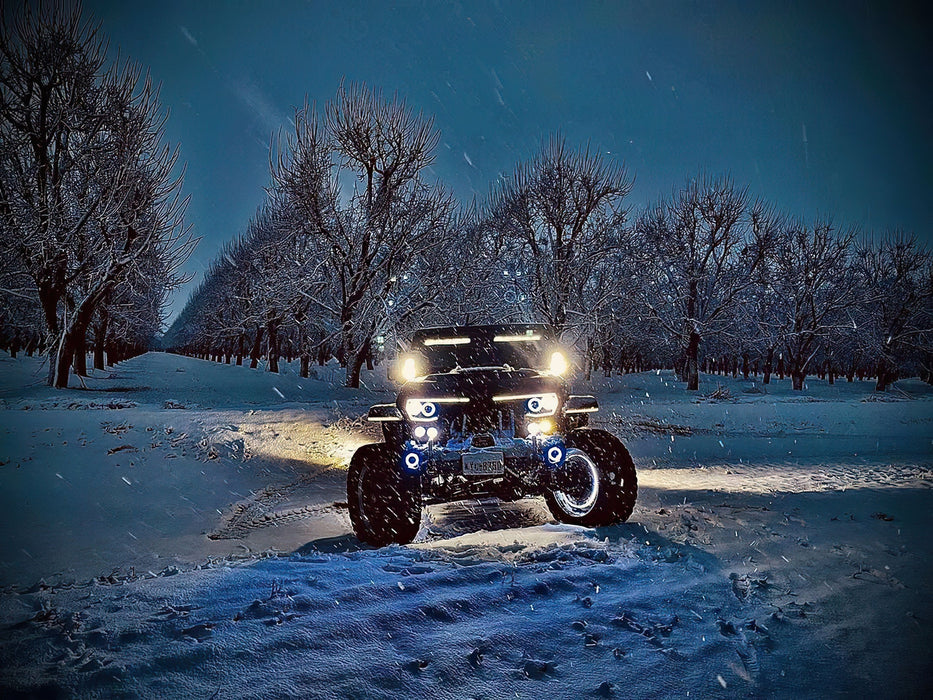 Front view of a Jeep in the snow with Vector™ Series Grill LED Halo Kit installed.
