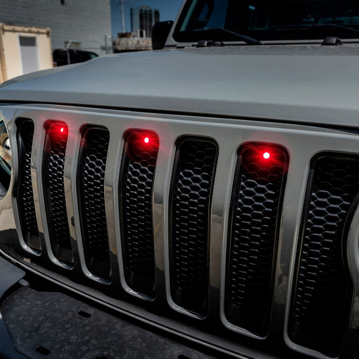 Front end of a Jeep Wrangler JL with red Pre-Runner Style LED Grill Light Kit installed.