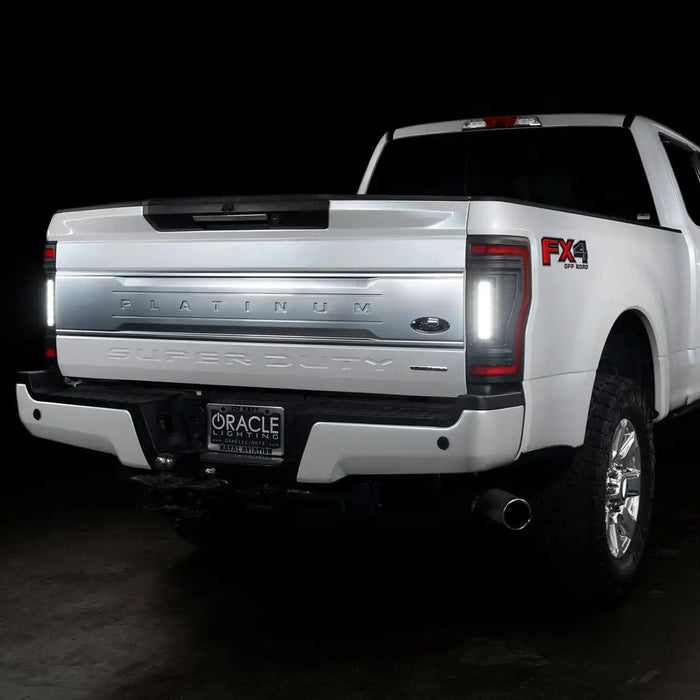 Rear three quarters view of a white Ford Superduty, with Flush Mount Tail Lights installed, and reverse lights on.