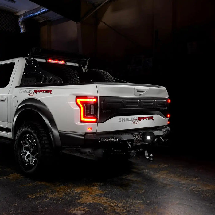 Rear three quarters view of white Ford Raptor with brake lights on
