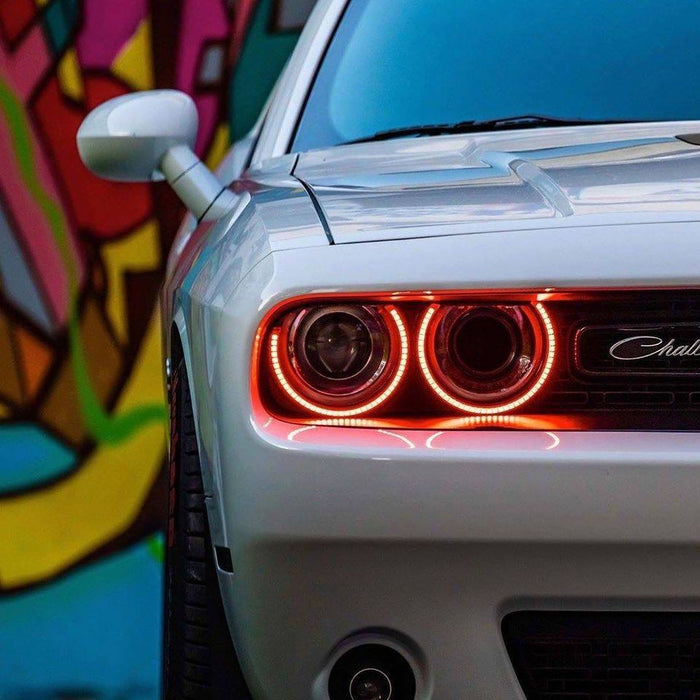 Close-up of amber LED headlight halo rings installed on a Dodge Challenger.
