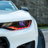 Close-up of a Camaro headlight with red DRLs.