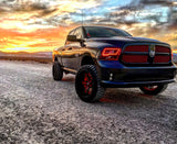 Three quarters view of a black RAM 1500 with red headlight halos.