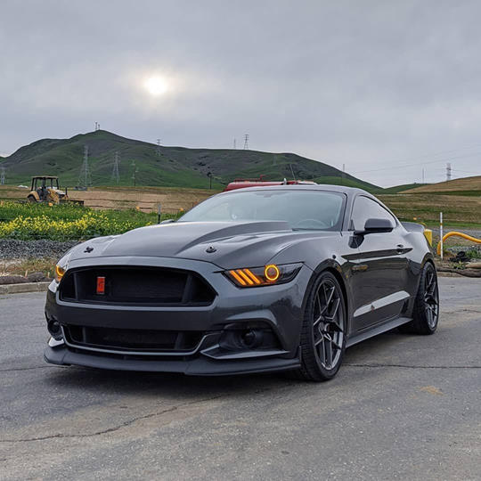 Three quarters view of a Ford Mustang with amber headlight halos and DRLs.