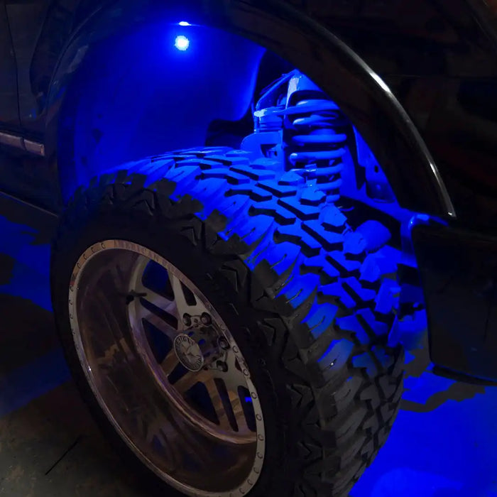 Close up of a wheel well with blue rock light glowing.