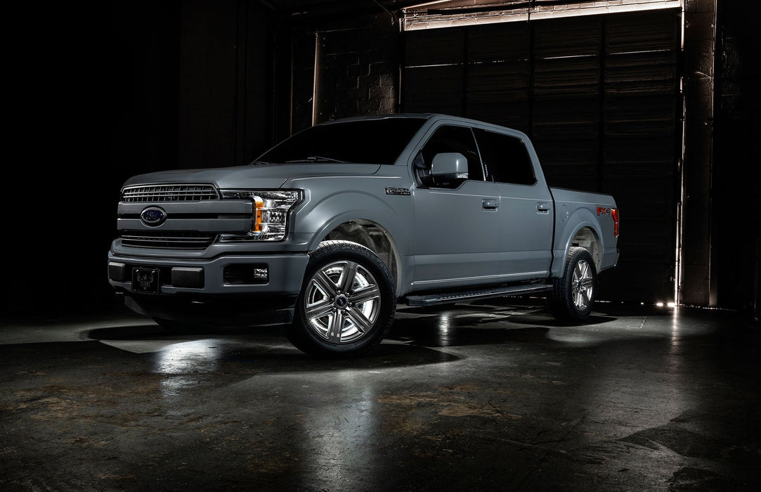 Grey Ford F-150 with white wheel rings and rock lights.