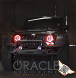 Front end of a Jeep Wrangler with red LED headlight halo rings installed.