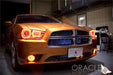 Front end of an orange Dodge Charger with amber LED headlight halo rings installed.