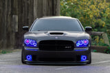 Black charger outside with blue headlight and fog light halos.