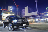 Three quarters view of a black Dodge Ram with white LED headlight halo rings installed.