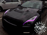 Black Nissan GT-R with pink headlight DRLs.