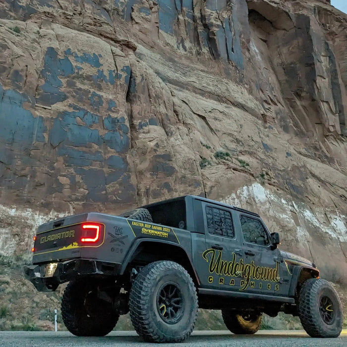 Rear three quarters view of a Jeep Gladiator JT in front of a cliff with Flush Mount LED Tail Lights installed.