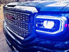 Close-up of a GMC Sierra headlight with blue DRLs.